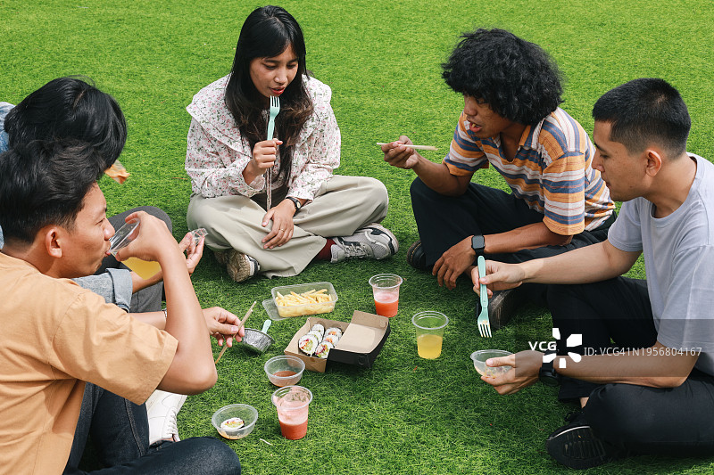 在公园里享用健康食品和饮料的不同人群图片素材