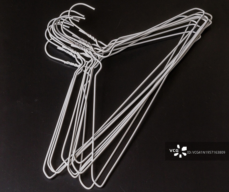 堆放在黑色背景上的白色金属衣架，韩国，亚洲图片素材