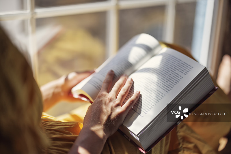 坐在窗台上看书的少女图片素材