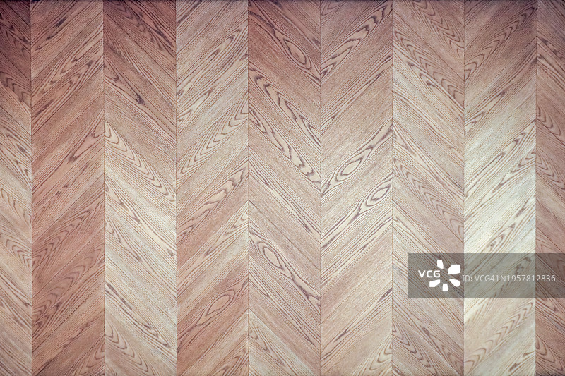 柔和灯光下的优雅人字形木纹墙图片素材