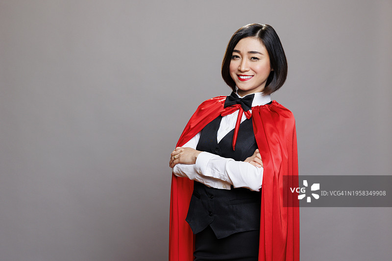 穿着西装站在灰色背景前的微笑女人肖像图片素材