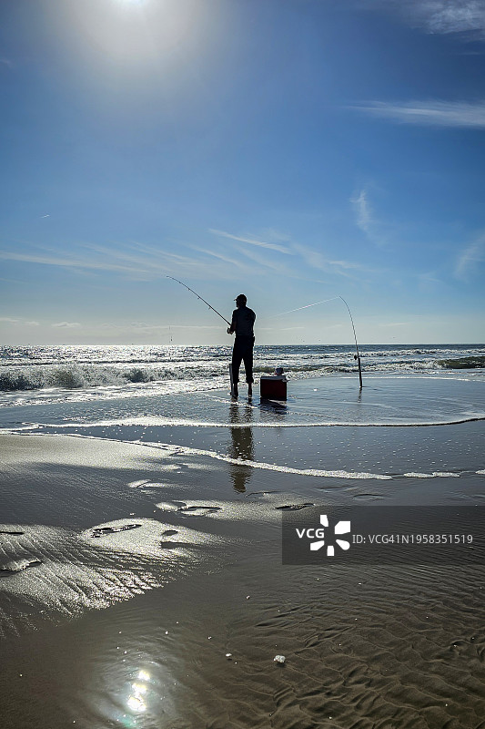 男人在海中对天空钓鱼图片素材