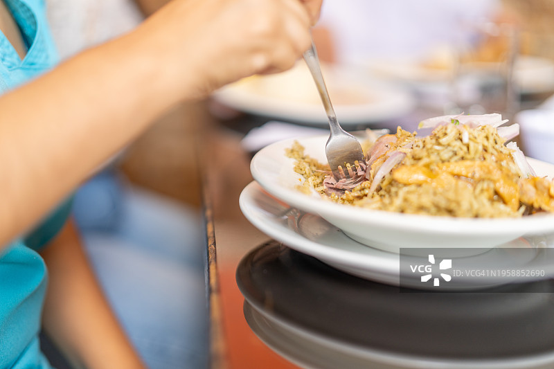 女人在餐厅里吃鸡肉饭图片素材