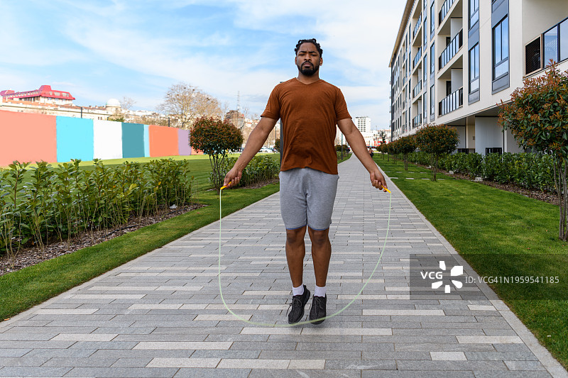 漂亮的年轻非洲男子在街上跳绳图片素材