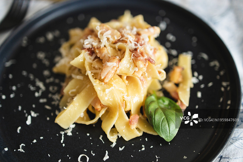 黑盘上的意式培根蛋面图片素材