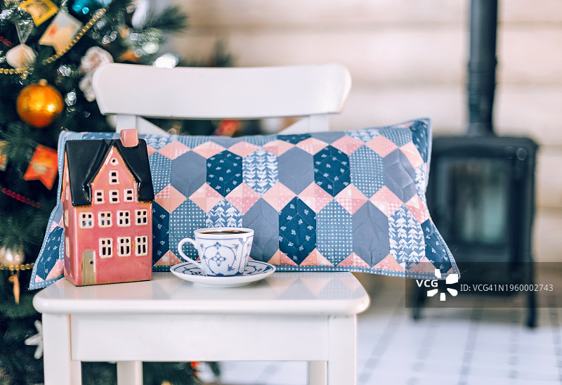 木扶手椅上的拼布抱枕与圣诞树，斯堪的纳维亚风图片素材