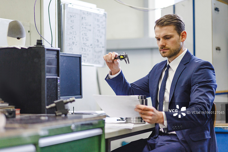 成年白人男性质检经理在生产设施检查文件和要求图片素材