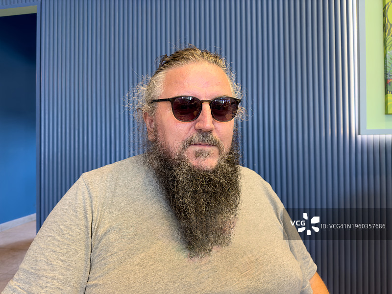 戴太阳镜的络腮胡男人摆姿势拍照图片素材