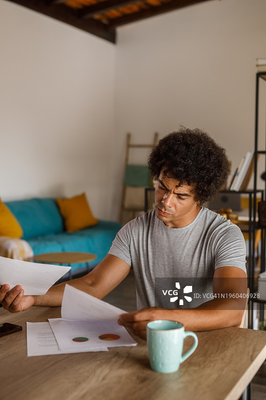 男人坐在桌旁，审查文件并签署合同图片素材
