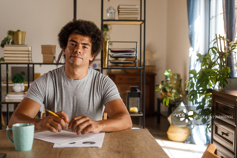 男人坐在桌旁，审查文件并签署合同图片素材