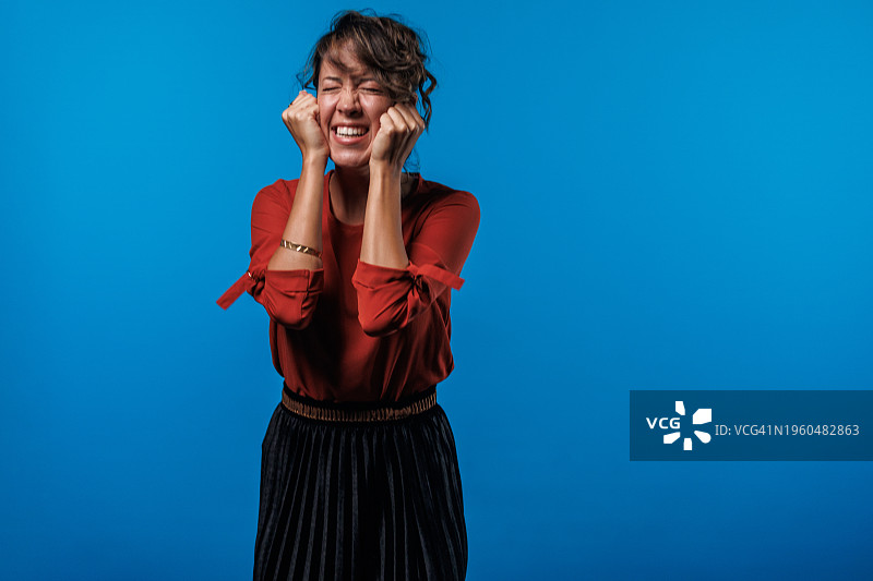 快乐的年轻女子兴奋地挥拳图片素材