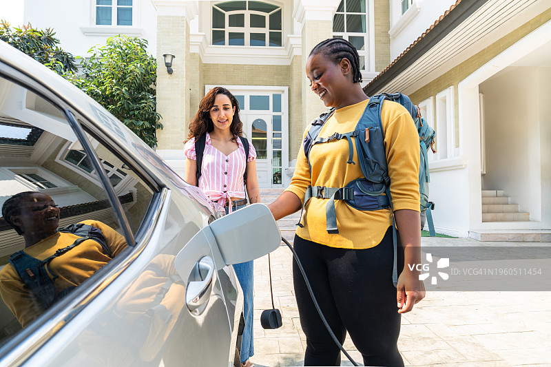 非洲中年妇女在家为电动汽车充电图片素材