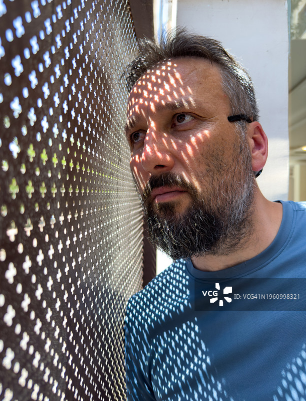 阳光穿过墙壁上的孔洞反射在人身上图片素材