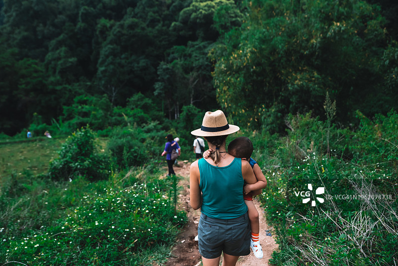 母亲抱着孩子在泰国清迈的步道上行走图片素材