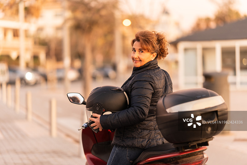 骑车人转过身来看着摩托车上的摄像头图片素材