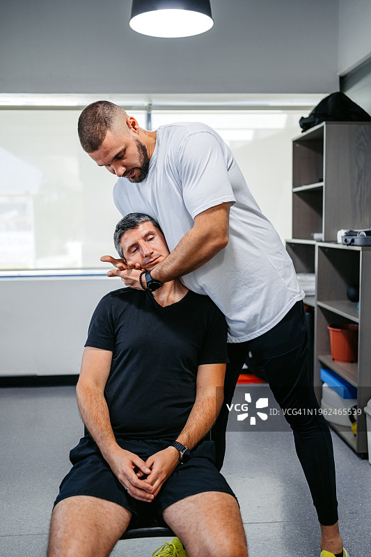 理疗师在办公室调整男顾客的颈部图片素材