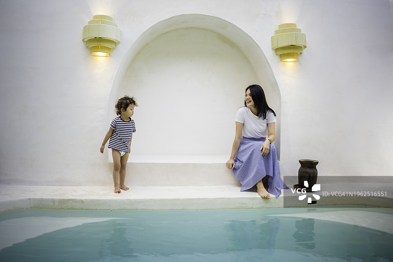 和儿子在泳池边休息的中国女人图片素材