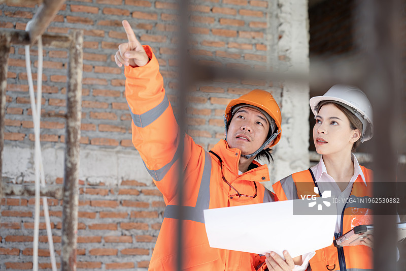 建筑项目中的质量管理：土木工程师与项目经理检查施工计划图片素材
