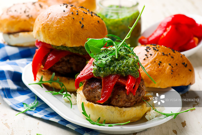 菲达奶酪酿火鸡汉堡配芝麻菜香蒜酱和烤红辣椒图片素材