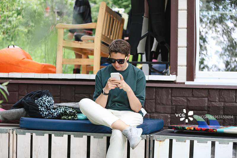 中年女自由职业者在运动营度假期间通过电话工作，看着设备屏幕图片素材