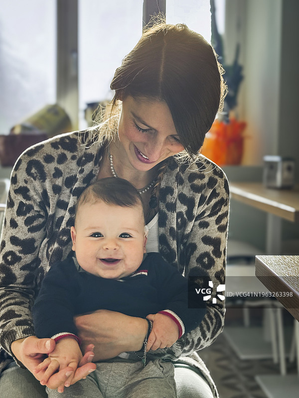 母亲抱着一个快乐的婴儿图片素材