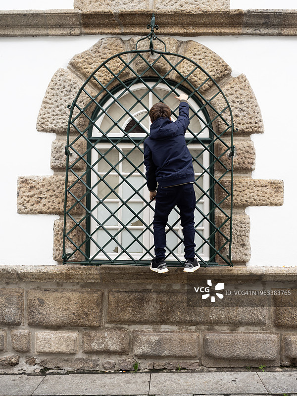 男孩爬窗户图片素材