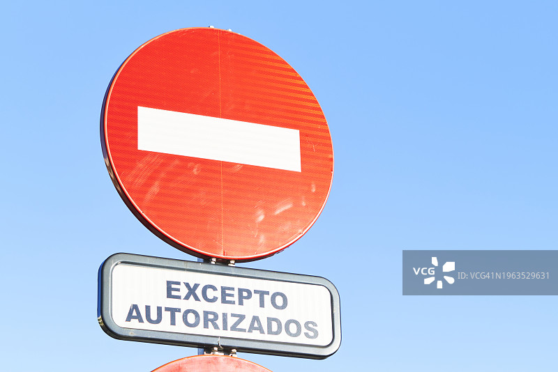 蓝天下，白色条纹的红色圆形交通标志和信息标志图片素材