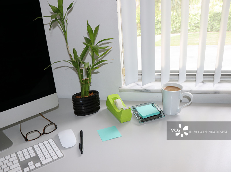 现代办公桌上的水蓝色便签和竹子图片素材