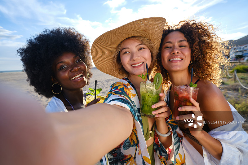 多民族朋友在户外喝鸡尾酒时自拍图片素材