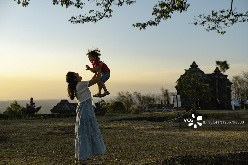 中国母亲在日惹Ratu Boko寺庙爬楼梯时牵着儿子的手图片素材