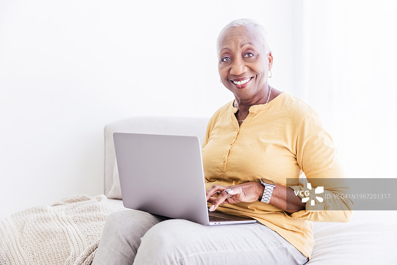 在家使用笔记本电脑的年长妇女图片素材