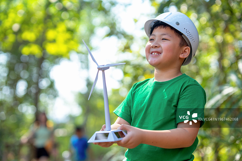 风力涡轮机探索者：公园里微笑的男孩 - 可持续解决方案图片素材