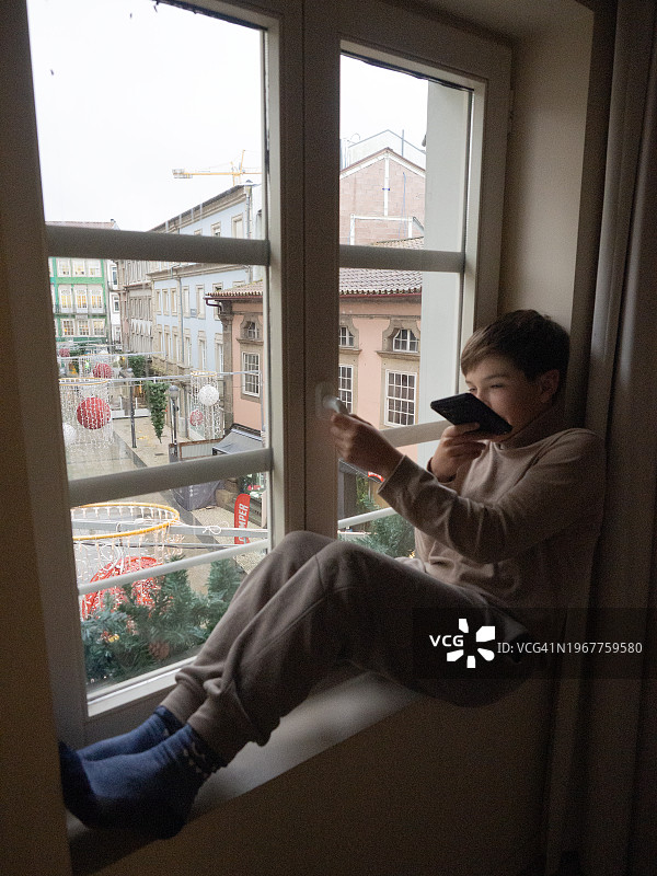 男孩在家用扬声器打电话图片素材