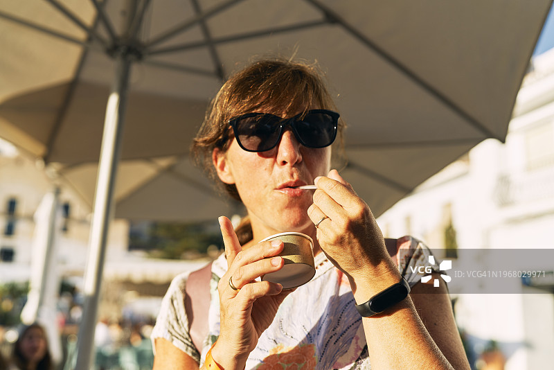 戴着墨镜、手持纸杯的妇女图片素材
