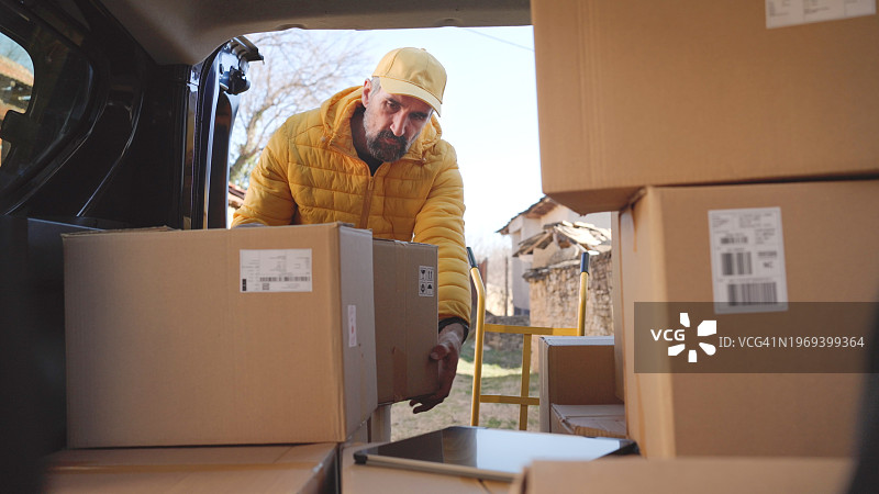 快递员装载邮政包裹准备派送图片素材
