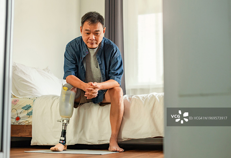 独自坐在卧室里的截肢男人图片素材