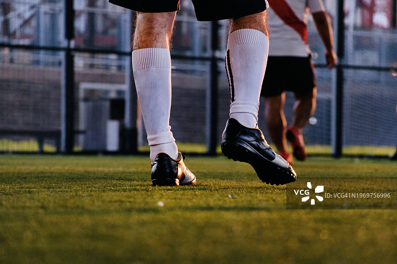 球场上足球运动员腿部特写图片素材