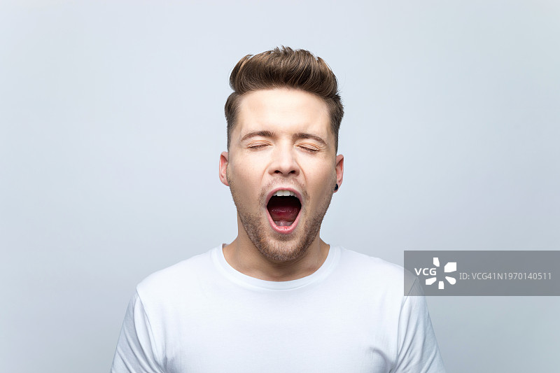 打呵欠的青年男子肖像图片素材