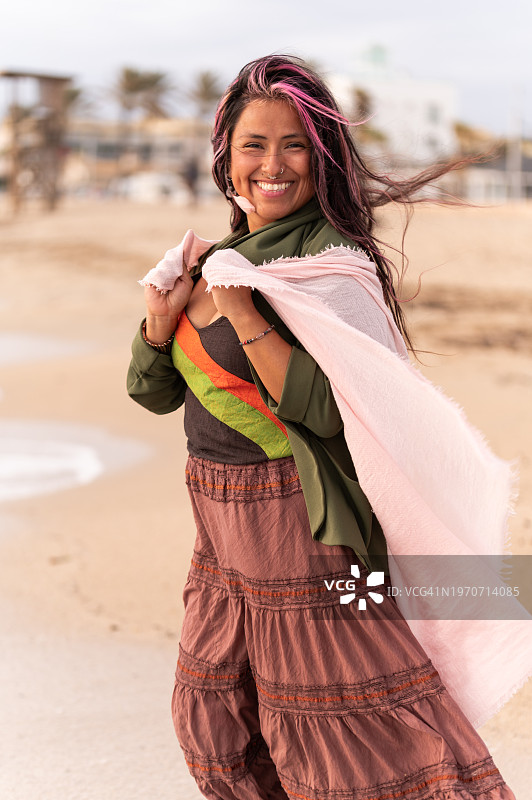 快乐的成年嬉皮士女性在海滩享受一天图片素材