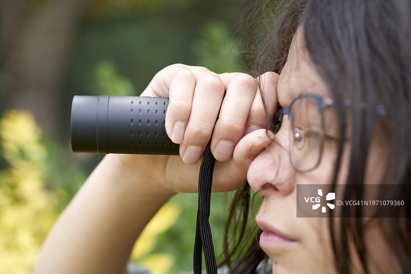 手持单筒望远镜的青少年图片素材