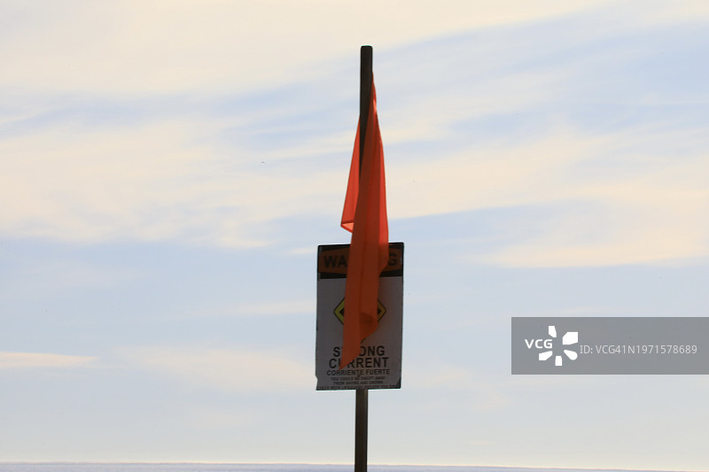 警告游泳者和冲浪者的海滩警告标志和彩色旗帜图片素材