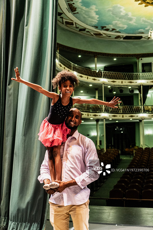 父亲在舞台上举起女儿的肖像图片素材