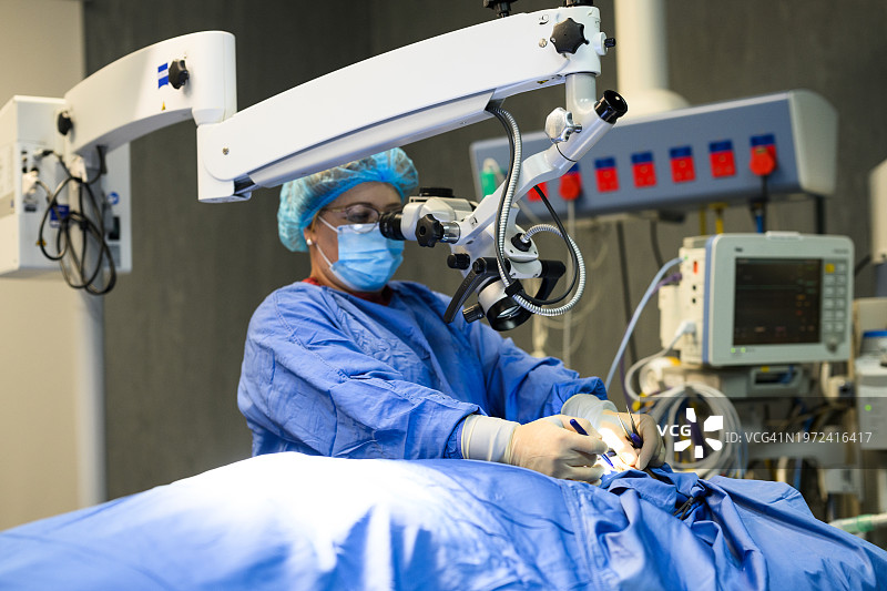 女外科医生在显微镜下观察人脸图片素材