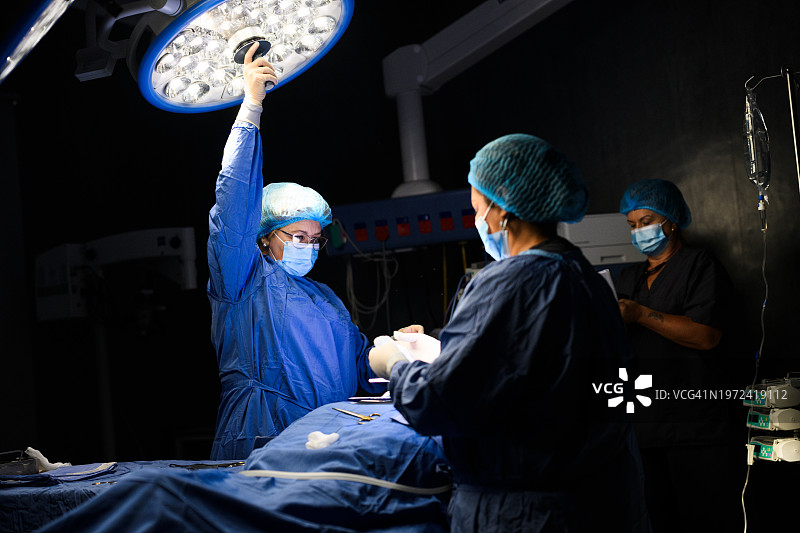女医生在手术室调整手术灯图片素材
