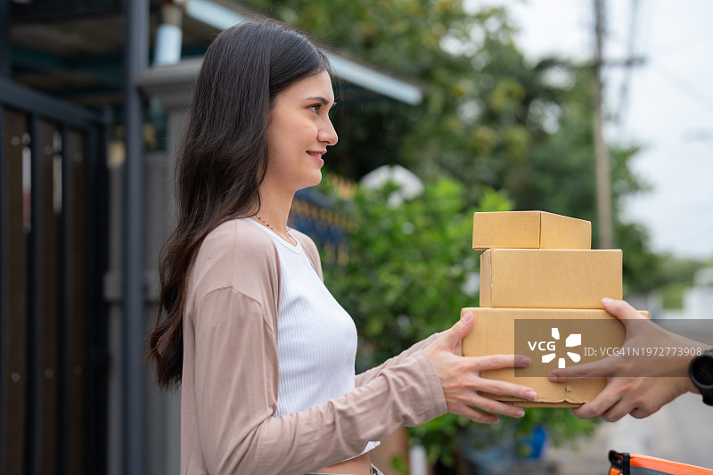 快递员送货上门，女顾客签字收货图片素材