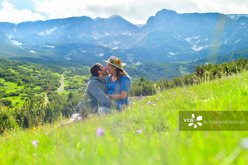在美丽山谷中亲吻的孕妇和丈夫图片素材