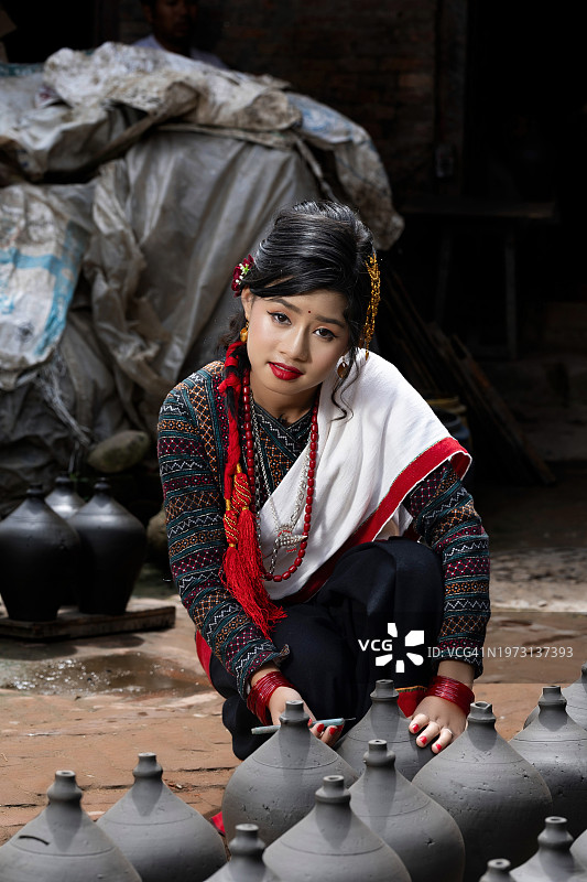 穿传统服饰的女人在户外制作陶罐图片素材