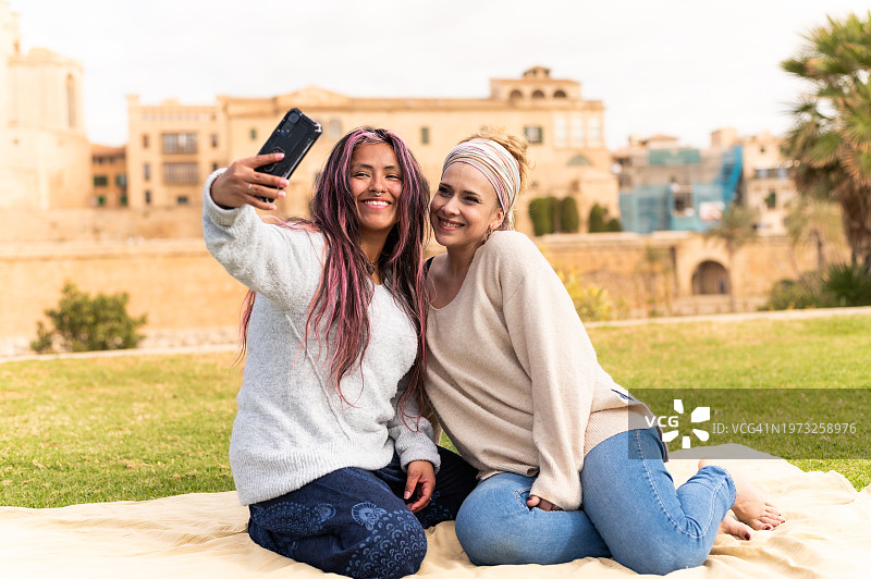 朋友们坐在公园里自拍图片素材