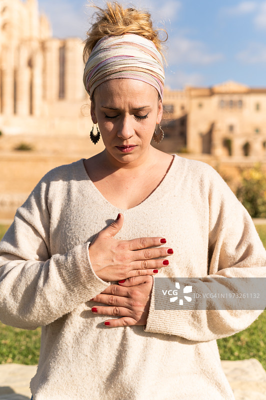闭着眼睛进行自我灵气疗法的女人图片素材