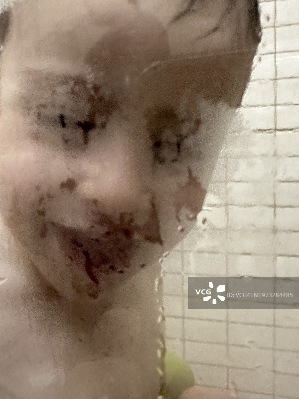 淋浴后在浴室里洗脸和玩水的三岁男孩图片素材